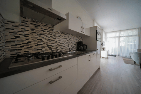 Cocina moderna en Pavilion de EuroParcs Veluwemeer, Países Bajos, con estufa de gas y pared de azulejos.