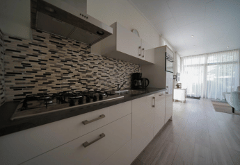 Cucina moderna al Pavilion presso EuroParcs Veluwemeer, Paesi Bassi, con piano cottura a gas e piastrelle.