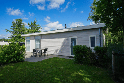 Moderno lodge Pavilion a EuroParcs Veluwemeer, Paesi Bassi, con terrazza e prato verde circostante.