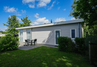 Moderne Pavillon-Lodge bei EuroParcs Veluwemeer in den Niederlanden mit Terrasse und Gartenmöbeln.