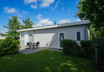 Moderno lodge Pavilion a EuroParcs Veluwemeer, Paesi Bassi, con terrazza e prato verde circostante.