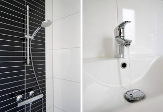 Douche moderne avec mur carrelé noir et blanc et robinetterie, plus lavabo avec robinet dans un lodge.