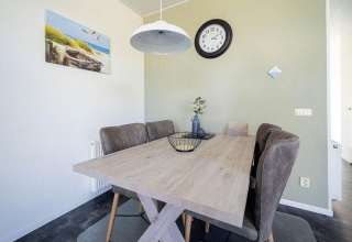 Sala da pranzo moderna in un lodge con tavolo in legno, sedie imbottite e decorazioni a parete.