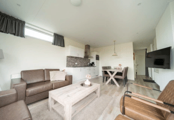 Heldere, moderne woonkamer met keuken en eetgedeelte in het Pavilion lodge bij EuroParcs Veluwemeer, Nederland.