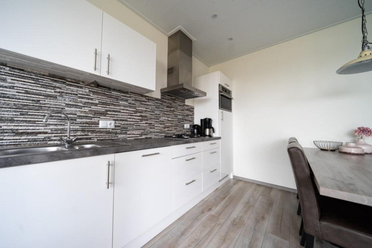 Cocina moderna y comedor en lodge del Pavilion en EuroParcs Veluwemeer, Países Bajos, de estilo elegante.