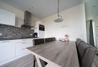 Cocina y comedor modernos en la cabaña Pavilion de EuroParcs Veluwemeer, Países Bajos, decoración elegante.