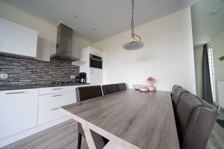 Cocina y comedor modernos en la cabaña Pavilion de EuroParcs Veluwemeer, Países Bajos, decoración elegante.