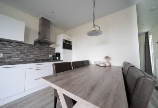 Moderna cucina e sala da pranzo nel lodge Pavilion a EuroParcs Veluwemeer, Paesi Bassi, arredamento elegante.