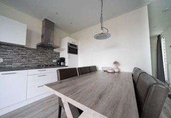 Moderna cucina e sala da pranzo nel lodge Pavilion a EuroParcs Veluwemeer, Paesi Bassi, arredamento elegante.