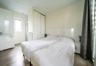 Lichte slaapkamer in Pavilion bij EuroParcs Veluwemeer, Nederland, met dubbel bed en ruime kast.