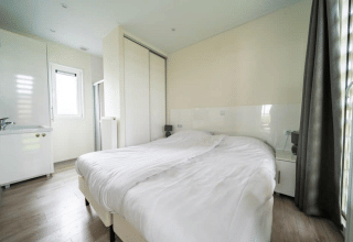 Camera luminosa presso il Pavilion di EuroParcs Veluwemeer, Paesi Bassi, con letto matrimoniale e armadio.