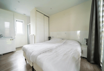 Lichte slaapkamer in Pavilion bij EuroParcs Veluwemeer, Nederland, met dubbel bed en ruime kast.