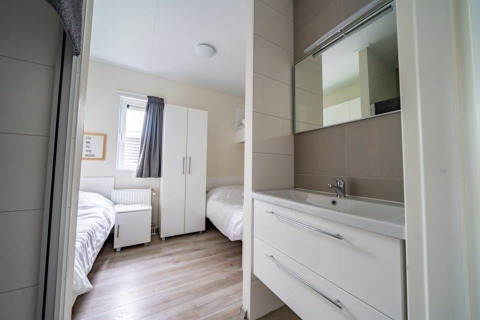 Chambre moderne au Pavilion d’EuroParcs Veluwemeer, Pays-Bas, lits jumeaux et lavabo contemporain.