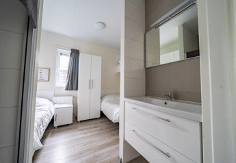 Camera moderna al Pavilion, EuroParcs Veluwemeer nei Paesi Bassi, con letti singoli e lavabo moderno.