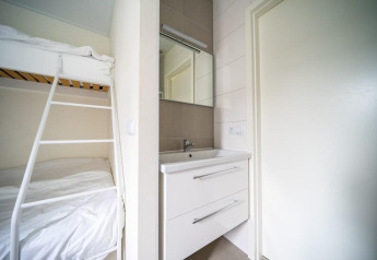 Modernes Lodge-Zimmer im Pavilion bei EuroParcs Veluwemeer, Niederlande, mit Etagenbett und Waschbecken.