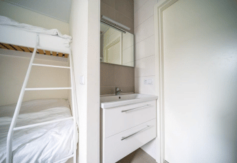 Moderne lodgekamer in het Pavilion bij EuroParcs Veluwemeer, Nederland, met stapelbed en wasmeubel.