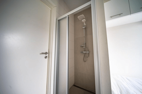 Cabina de ducha junto a un dormitorio en Pavilion de EuroParcs Veluwemeer, Países Bajos, vista desde la puerta.