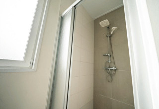 Doccia moderna con porta in vetro e finestra al Pavilion presso EuroParcs Veluwemeer nei Paesi Bassi.