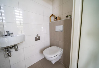 Bagno moderno con piastrelle e wc sospeso al Pavilion di EuroParcs Veluwemeer nei Paesi Bassi.