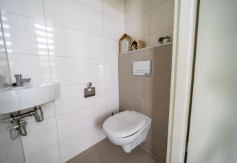 Modern betegelde toiletruimte in Pavilion bij EuroParcs Veluwemeer, Nederland, met wandtoilet.