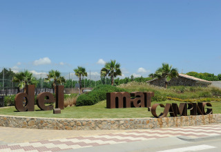 Eingang des Camping del Mar Ferienparks in Katalonien, Spanien mit Palmen und großen Buchstaben bei Sonne.