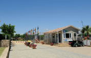 Ingang van Camping del Mar vakantiepark in Catalonië, Spanje, met vlaggen, receptie en golfkarretje.