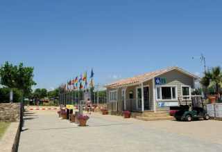 Ingang van Camping del Mar vakantiepark in Catalonië, Spanje, met vlaggen, receptie en golfkarretje.