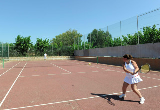 To personer spiller tennis på en udendørs bane ved Camping del Mar feriepark i Catalonien, Spanien.