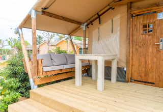 Udendørs terrasse af en safaritelte på Glamping Mar, Camping del Mar, Spanien, med bænk og bord.