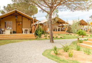 Safaritenten bij Glamping Mar op Camping del Mar in Spanje, met houten veranda’s en groene tuin.