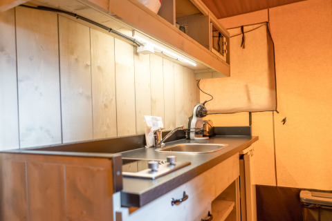Área de cocina en una tienda safari de Glamping Mar en Camping del Mar, España, con fregadero y cafetera.