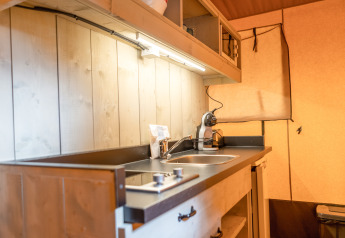 Área de cocina en una tienda safari de Glamping Mar en Camping del Mar, España, con fregadero y cafetera.