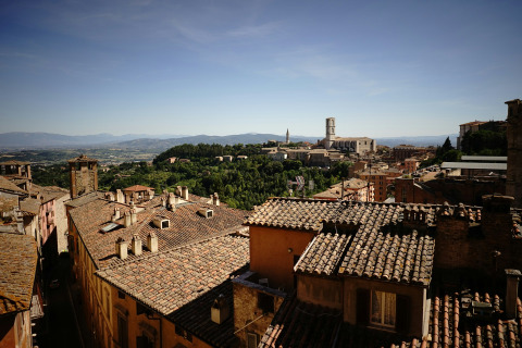 View of traditional tiled rooftops and the surrounding landscape near Bevagna, Umbria, Italy, on a sunny day.