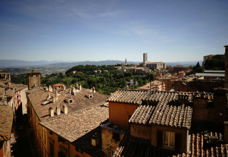 View of traditional tiled rooftops and the surrounding landscape near Bevagna, Umbria, Italy, on a sunny day.