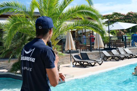 Hombre con camiseta Seasonova junto a la piscina en Camping Seasonova Haliotis, Normandía, Francia.