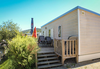 Mobilheim O'Hara mit Terrasse und Liegestühlen auf Camping Lac des Brenets, Schweiz, bei Sonnenschein