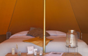 Innenansicht eines stilvollen Tipis mit Doppelbett bei Bell Escape, Little Canvas Escape in den Niederlanden.