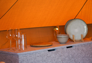 Vaisselle et verres dans le tipi Bell Escape à Little Canvas Escape, Pays-Bas, sur une table.