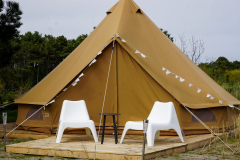 Foto della tenda teepee Bell Escape con due sedie bianche a Little Canvas Escape, Paesi Bassi.