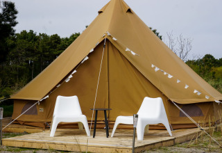 Foto della tenda teepee Bell Escape con due sedie bianche a Little Canvas Escape, Paesi Bassi.