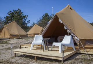 Tente tipi Bell Escape avec terrasse en bois et chaises blanches à Little Canvas Escape aux Pays-Bas.