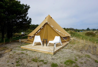 Una tienda tipi Bell Escape Family en Little Canvas Escape, Países Bajos, con dos sillas blancas delante.