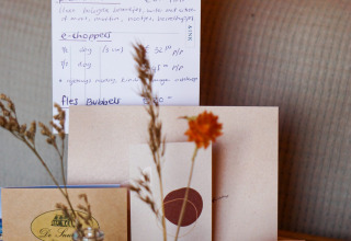 Interior de tipi con carta del menú, flores secas en frascos y decoración en Little Canvas Escape, Países Bajos.