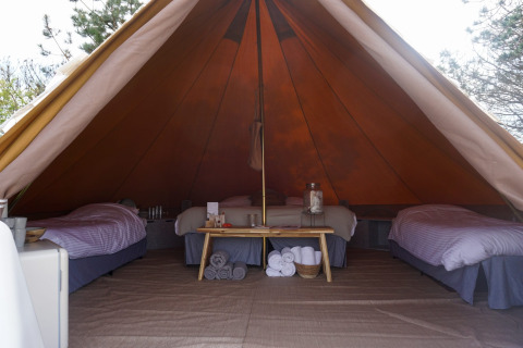 Vista interior de la tienda tipi Bell Escape Family en Little Canvas Escape, Países Bajos, con tres camas.