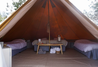 Vista interior de la tienda tipi Bell Escape Family en Little Canvas Escape, Países Bajos, con tres camas.