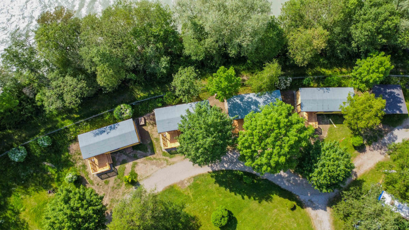 Vue aérienne du parc de vacances Drau Camping Sachsenburg en Carinthie, Autriche, avec des cabines et des arbres.