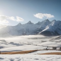 Montañas nevadas cerca de Kramsach en Tirol, Austria, iluminadas por el sol de la mañana y algo de niebla.
