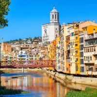 Edificios coloridos junto al río y la catedral de Girona cerca de Pals, Cataluña, España, en un día soleado.