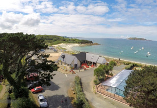 Camping Seasonova Les 7 Iles in Brittany, France, with seaside views, a pool, and boats on the water.