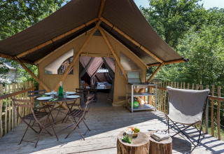 Safari tent Canadian Tent at Village Huttopia Lagoa de Óbidos, Portugal, with deck, dining set and forest view.